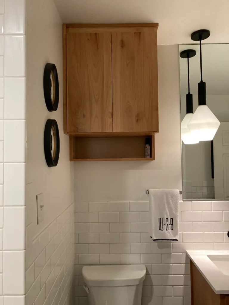 Modern bathroom with floating wood cabinetry, white subway tile, and pendant lighting