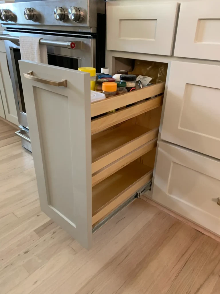 Custom pull-out kitchen storage drawer with tiered shelving for spices and pantry organization