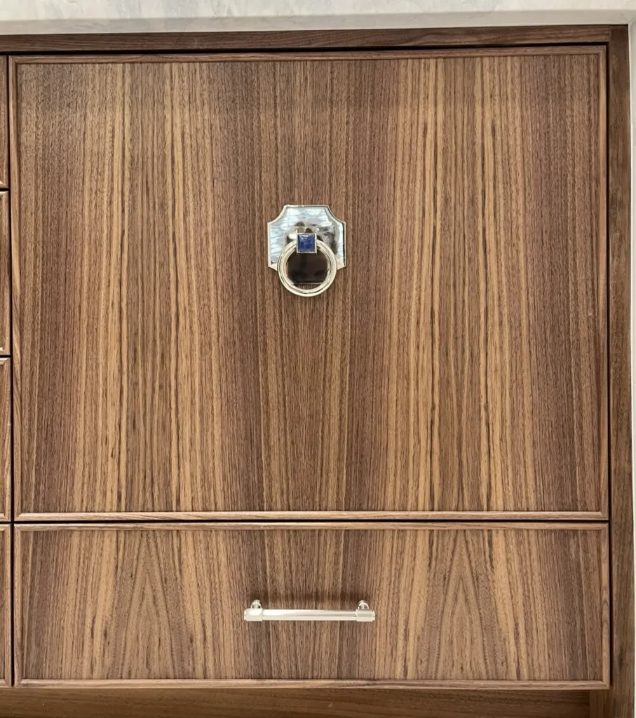 Custom wood cabinetry detail with decorative hardware and rich natural grain finish