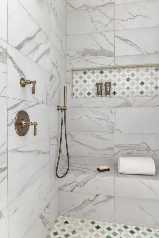 Luxury marble walk-in shower with built-in niche and brass fixtures