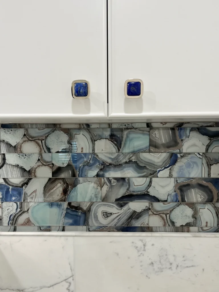 Decorative blue agate tile backsplash with white cabinetry and custom blue cabinet hardware