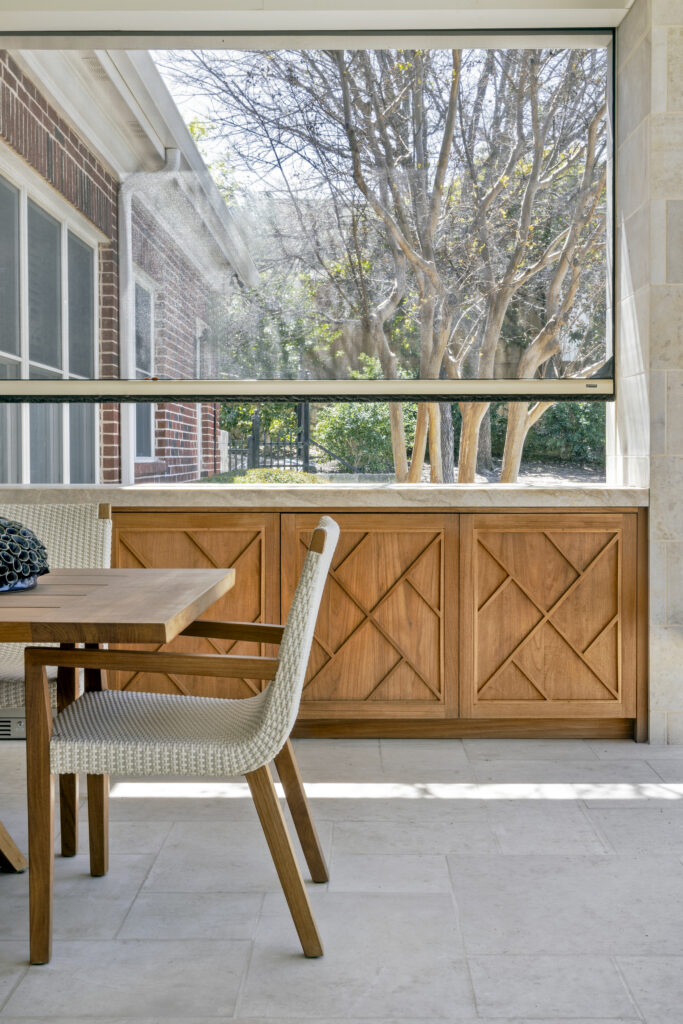 Outdoor dining area with custom wood cabinetry and open patio view at a luxury home