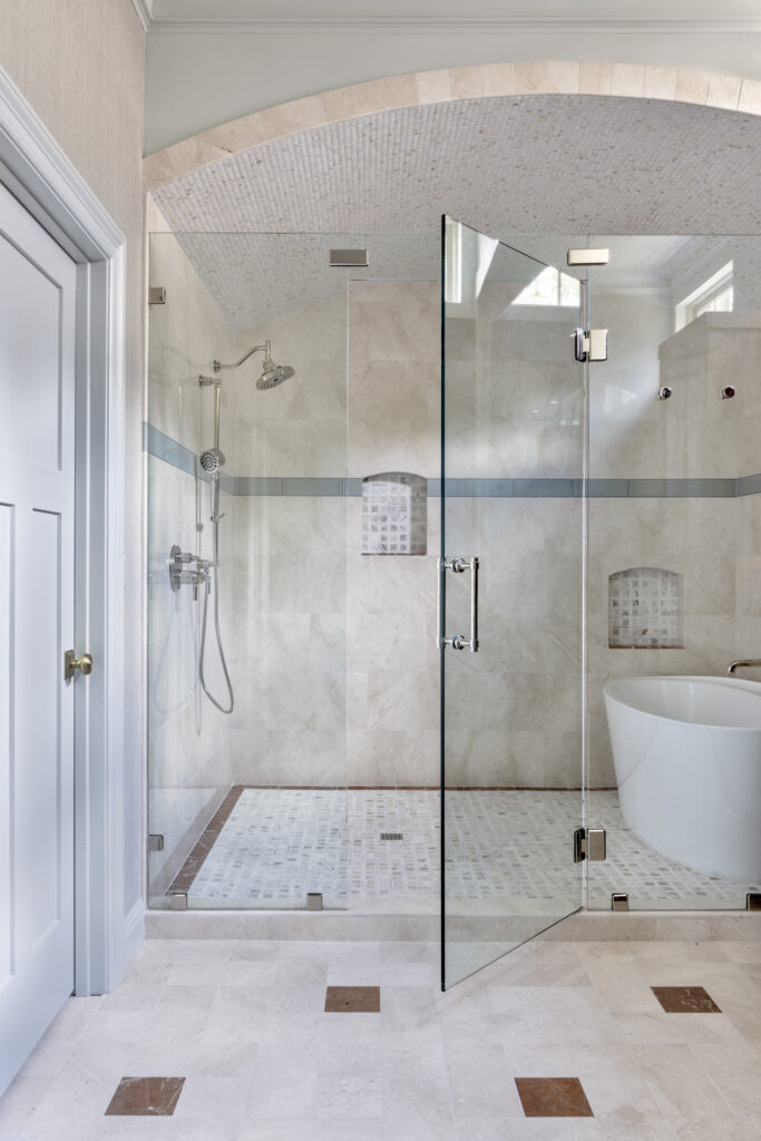 Spacious luxury walk-in shower with frameless glass enclosure, mosaic ceiling, and freestanding soaking tub