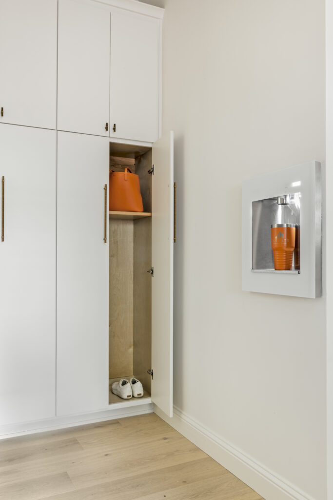Built-in white storage cabinetry with hidden shelving and recessed display niche in a luxury home interior
