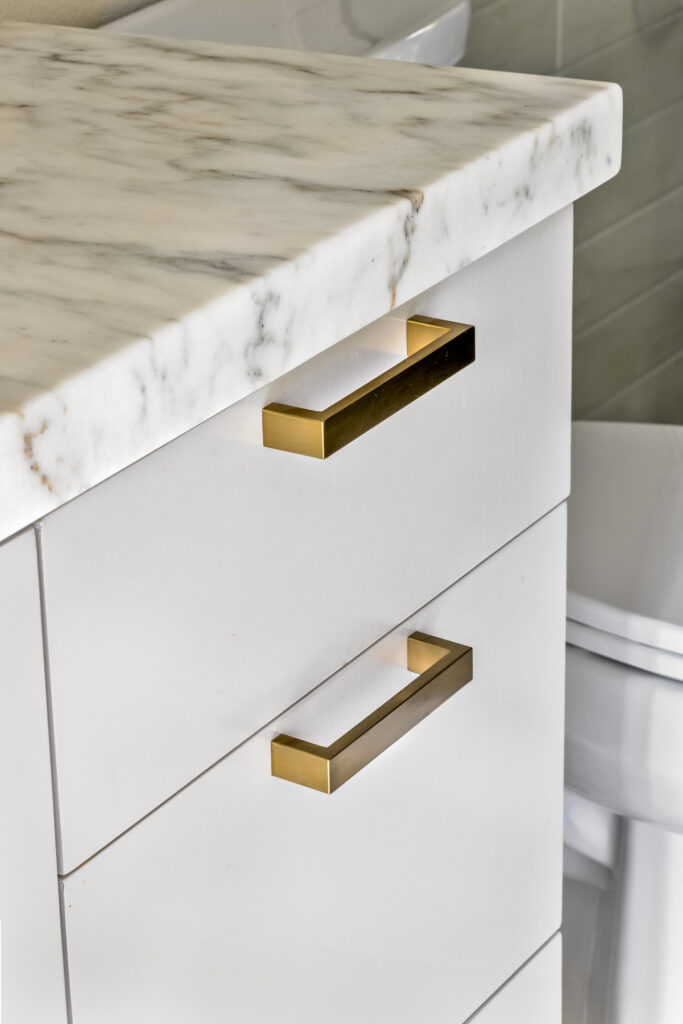 Marble bathroom vanity countertop with brushed brass hardware in a luxury home