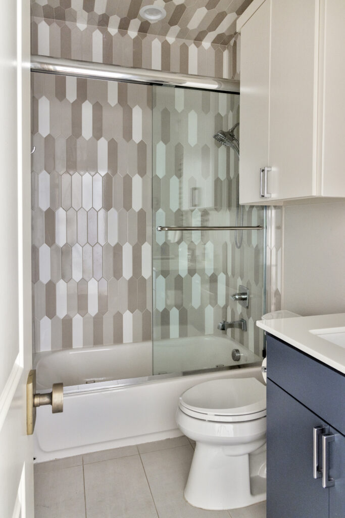 Modern bathroom with patterned tile shower and glass enclosure in a luxury home