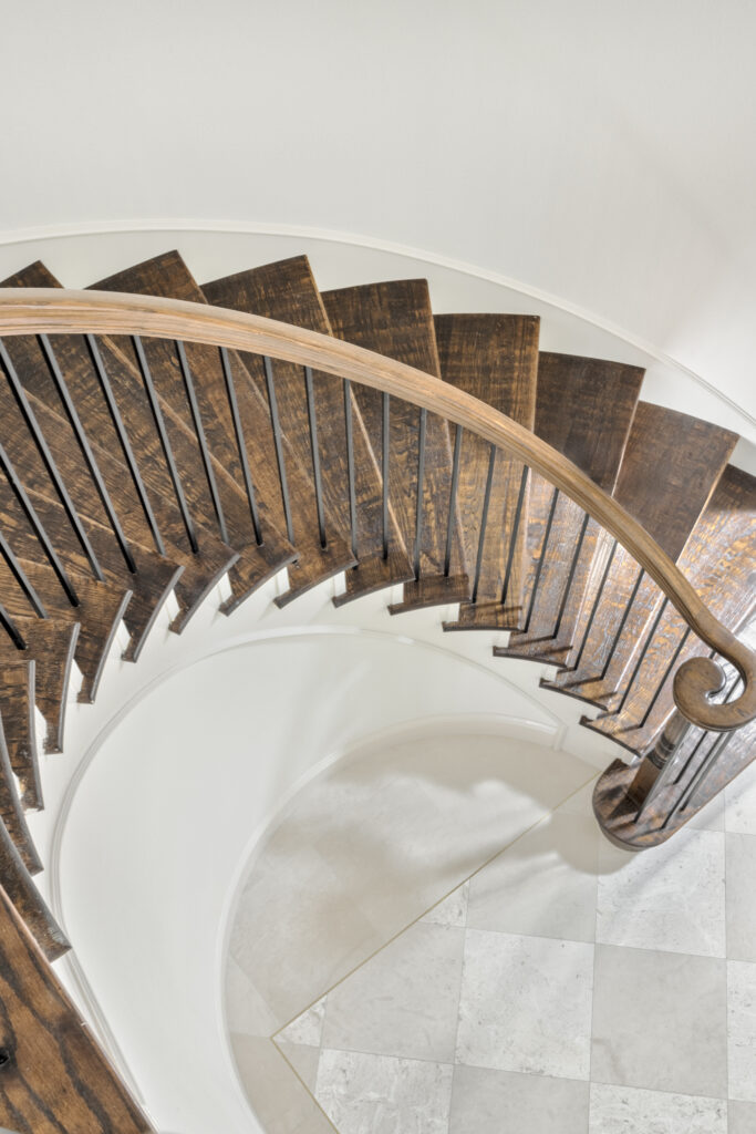 Curved wood staircase with custom railing in a luxury home interior
