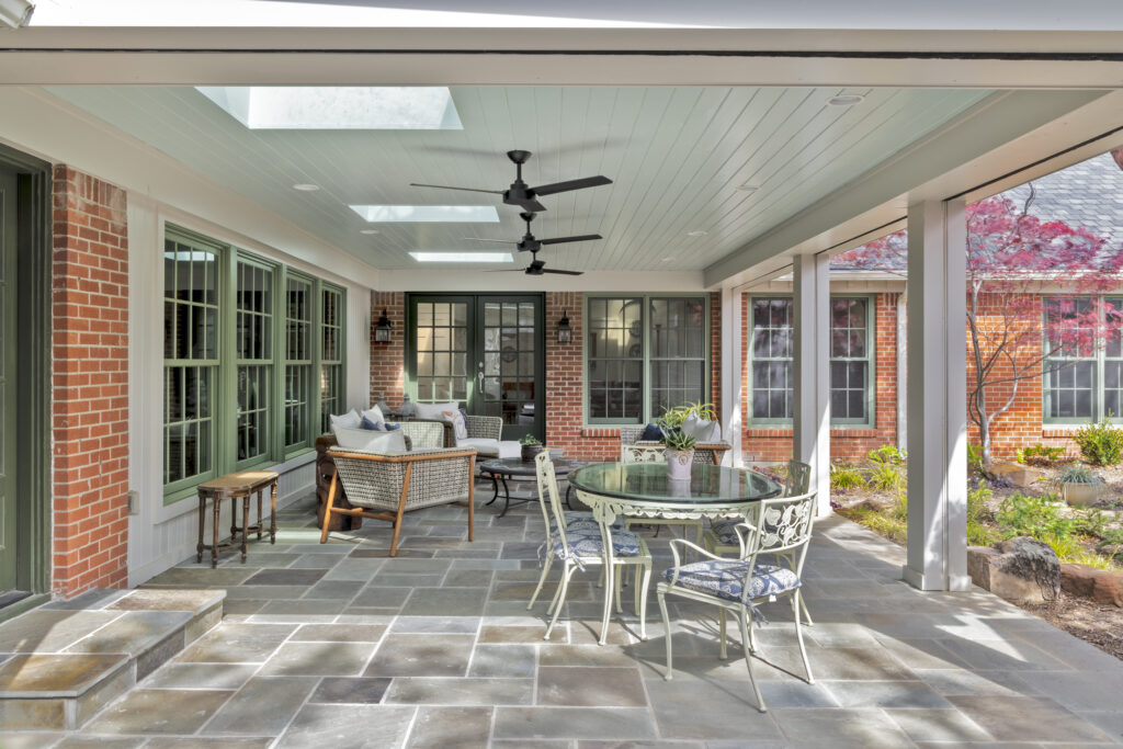 Covered outdoor patio with lounge seating and ceiling fans at a luxury Fort Worth home