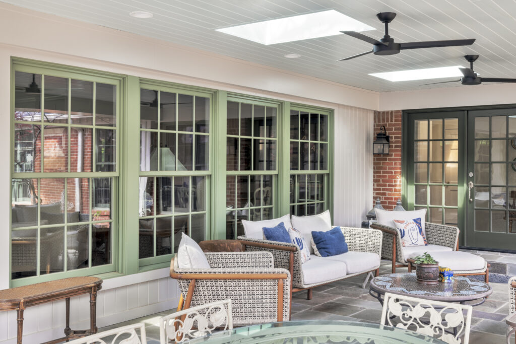 Covered outdoor patio with lounge seating and ceiling fans at a luxury Fort Worth home